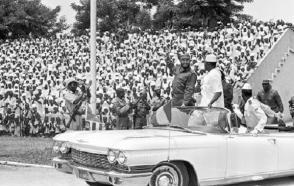Fidel Castro durante su visita a Guinea, en el acto en honor a la delegación cubana, en el estadio "28 de septiembre". Lo acompaña Ahmed Sekou Touré, presidente de ese país y Agosthino Neto, presidente del Movimiento para la Liberación de Angola, el 5 de mayo de 1972.